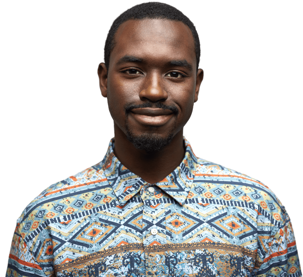 Smiling man in a colorful patterned shirt, standing against a plain background.